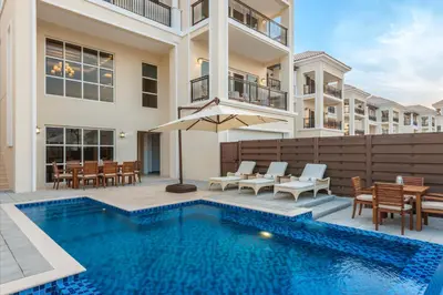 a villa with a swimming pool and a house at Al Habtoor Polo Resort in Dubai
