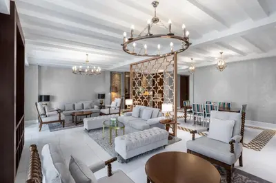 a living room with white furniture and a chandelier at Al Habtoor Polo Resort in Dubai