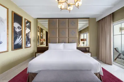 a bedroom with a large bed and a chandelier at Al Habtoor Polo Resort in Dubai
