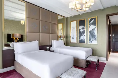 a bedroom with two beds and a chandelier at Al Habtoor Polo Resort in Dubai