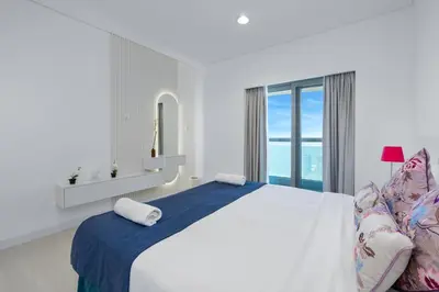 a white bedroom with a large bed and a window at Princess Tower Dubai Marina private Spa amazing view in Dubai