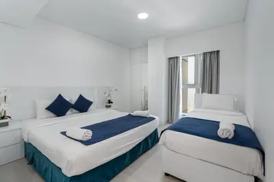 a white bedroom with two beds and a window at Princess Tower Dubai Marina private Spa amazing view in Dubai
