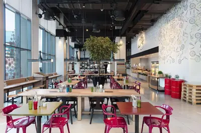 a restaurant with wooden tables and red chairs at Rove Trade Centre in Dubai