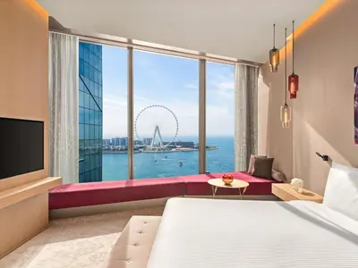 a hotel room with a bed and a large window at Rixos Premium Dubai JBR in Dubai
