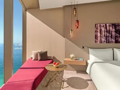 a hotel room with two beds and a table at Rixos Premium Dubai JBR in Dubai
