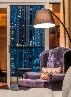 a purple chair and a lamp in a room with a window at Radisson Blu Hotel, Dubai Waterfront in Dubai