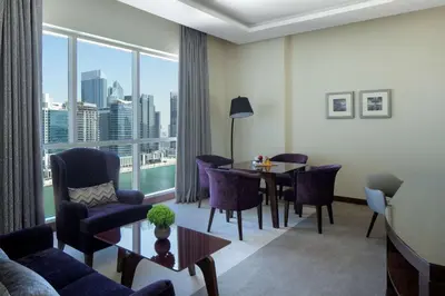 a living room with a table and chairs and a large window at Radisson Blu Hotel, Dubai Waterfront in Dubai