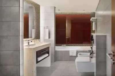 a bathroom with a toilet and a sink and a tub at Radisson Blu Hotel, Dubai Waterfront in Dubai