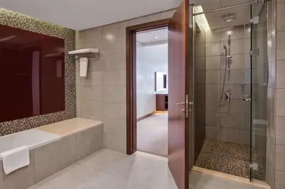 a bathroom with a shower and a tub and a sink at Radisson Blu Hotel, Dubai Waterfront in Dubai