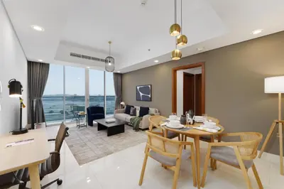 a dining room and living room with a table and chairs at Maison Privee - Modern Business Bay Retreat with Dubai Canal Views in Dubai