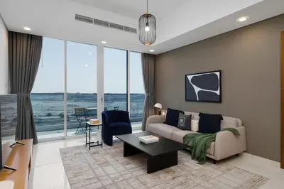 a living room with a couch and a table at Maison Privee - Modern Business Bay Retreat with Dubai Canal Views in Dubai