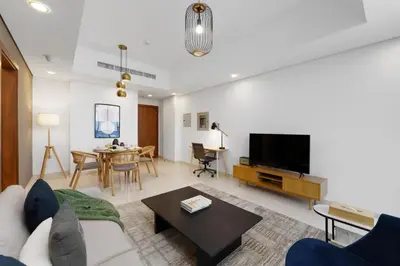a living room with a couch and a tv at Maison Privee - Modern Business Bay Retreat with Dubai Canal Views in Dubai