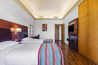 a hotel room with a large bed and a television at Al Khoory Hotel Apartments Al Barsha in Dubai