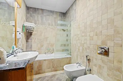 a bathroom with a sink and a toilet and a tub at Al Khoory Hotel Apartments Al Barsha in Dubai
