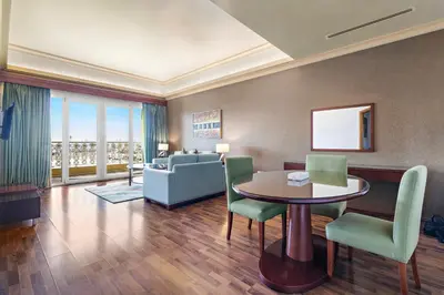 a living room with a table and chairs and a couch at Al Khoory Hotel Apartments Al Barsha in Dubai