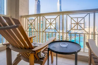 a balcony with chairs and a table and a view of the city at New Arabian 29 Boulevard Downtown in Dubai