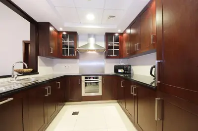 a large kitchen with wooden cabinets and a sink at New Arabian 29 Boulevard Downtown in Dubai