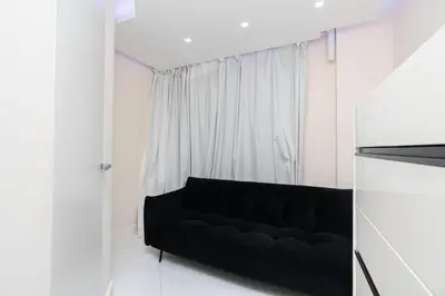 a black couch in a white room with a window at JBR Luxury Penthouse with private pool, cinema, gym, spa etc in Dubai