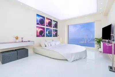 a white bedroom with a large bed and a flat screen tv at JBR Luxury Penthouse with private pool, cinema, gym, spa etc in Dubai