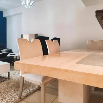 a dining room with a wooden table and chairs at Elan Rimal2 Suites in Dubai