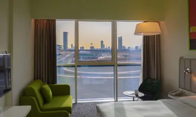 a hotel room with a large window with a view of the city at Park Inn by Radisson Dubai Motor City in Dubai