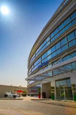 a building with a racing car parked in front of it at Park Inn by Radisson Dubai Motor City in Dubai