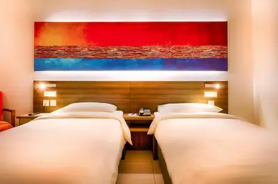 two beds in a hotel room with a painting on the wall at Citymax Hotel Al Barsha at the Mall in Dubai