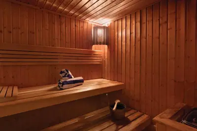 a wooden sauna with a stuffed animal sitting on a shelf at Montreal Barsha Hotel in Dubai