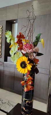 a vase filled with flowers on a table at Montreal Barsha Hotel in Dubai