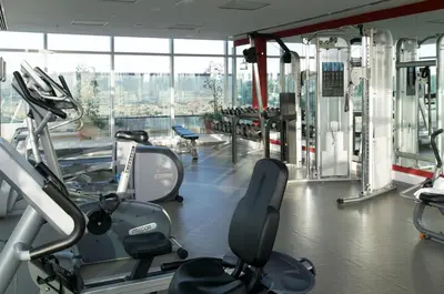 a gym with cardio equipment and a large window at Montreal Barsha Hotel in Dubai