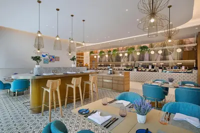 a restaurant with blue chairs and a bar at Residence Inn by Marriott Sheikh Zayed Road, Dubai in Dubai