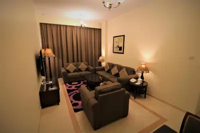 a living room with a couch and chairs and a tv at Baity Hotel Apartments in Dubai