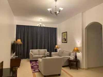 a living room with two chairs and a couch at Baity Hotel Apartments in Dubai