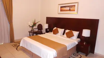a bedroom with a large bed with a wooden headboard at Akas-Inn Hotel Apartment in Dubai