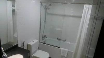 a bathroom with a shower and a toilet and a sink at Akas-Inn Hotel Apartment in Dubai