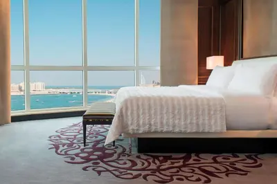 a bedroom with a large bed and a large window at Le Meridien Mina Seyahi Beach Resort & Waterpark in Dubai