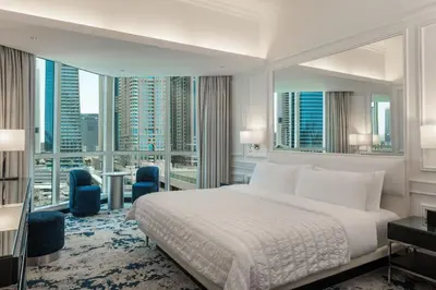 a bedroom with a large bed and large windows at Le Meridien Mina Seyahi Beach Resort & Waterpark in Dubai