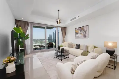 a living room with white furniture and a large window at Maison Privee - Ultimate Living with Front-Row Views of Burj Khalifa & Dubai Fountains in Dubai