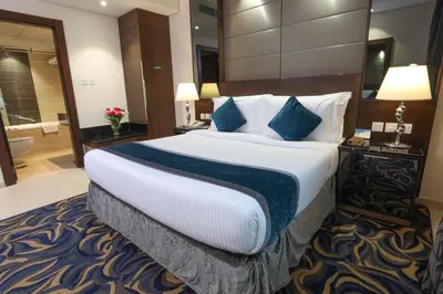a hotel room with a large bed and a bathroom at Omega Hotel Dubai in Dubai