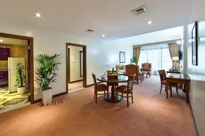 a living room with a table and a dining room at Rolla Residence Hotel Apartment in Dubai