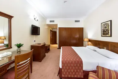 a hotel room with a bed and a desk and a television at Rolla Residence Hotel Apartment in Dubai