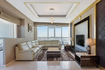 a living room with a couch and a television at DAMAC Maison Distinction in Dubai