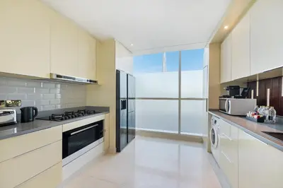 a large kitchen with white cabinets and appliances at DAMAC Maison Distinction in Dubai