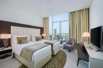 a hotel room with a bed and a television at DAMAC Maison Distinction in Dubai