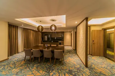 a dining room with a table and a kitchen at MENA Plaza Hotel Albarsha At The Mall in Dubai