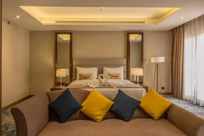 a large bedroom with a large bed with yellow pillows at MENA Plaza Hotel Albarsha At The Mall in Dubai