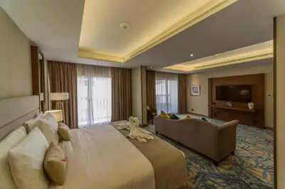 a hotel room with a large bed and a couch at MENA Plaza Hotel Albarsha At The Mall in Dubai