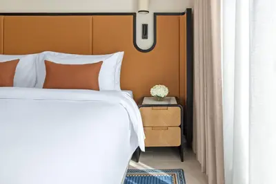 a bedroom with a bed and a nightstand next to a window at Oaks Ibn Battuta Gate Dubai in Dubai