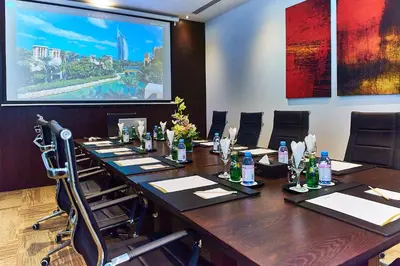a conference room with a long table and chairs at Rose Park Hotel - Al Barsha, Opposite Metro Station in Dubai
