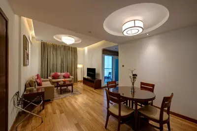 a living room with a table and a couch at Rose Park Hotel - Al Barsha, Opposite Metro Station in Dubai